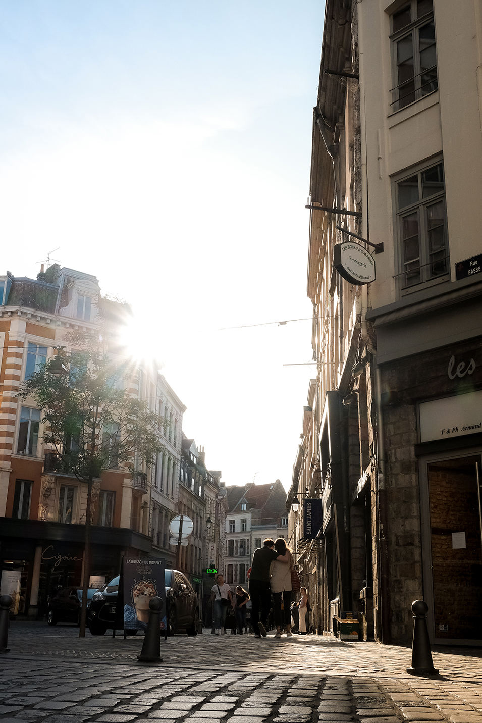 Rue lilloise avec un couple marchant au soleil
