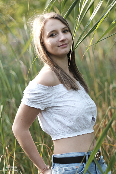 Une femme en train poser dans un jardin